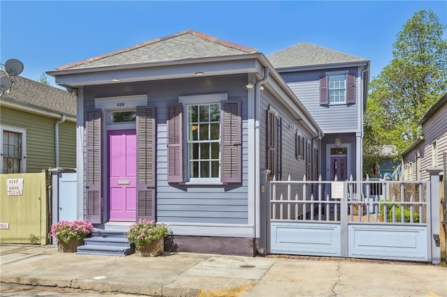 shotgun-style home with a shingled roof