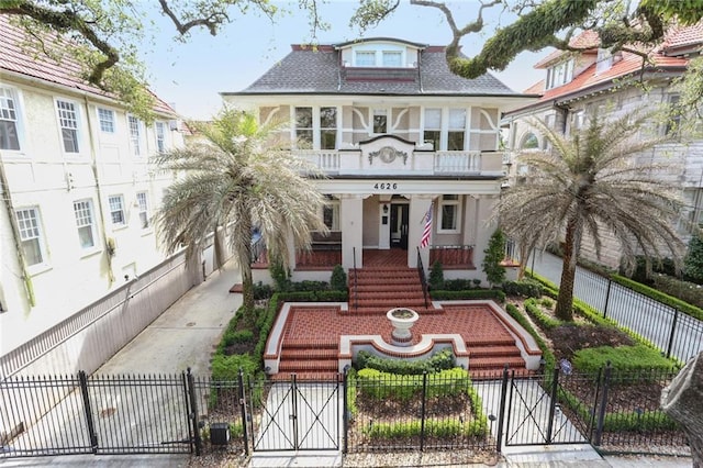 view of front of property featuring a fenced front yard, covered porch, and a gate