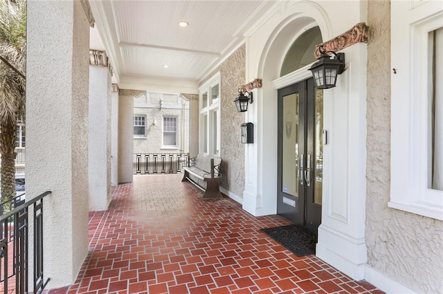 entrance to property with covered porch and stucco siding