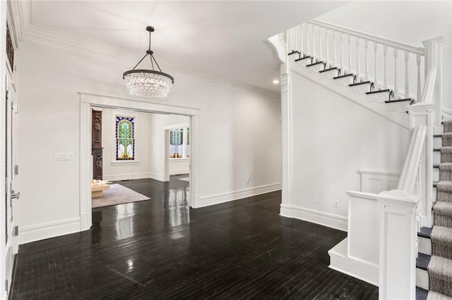 entrance foyer with wood finished floors, baseboards, an inviting chandelier, stairs, and crown molding