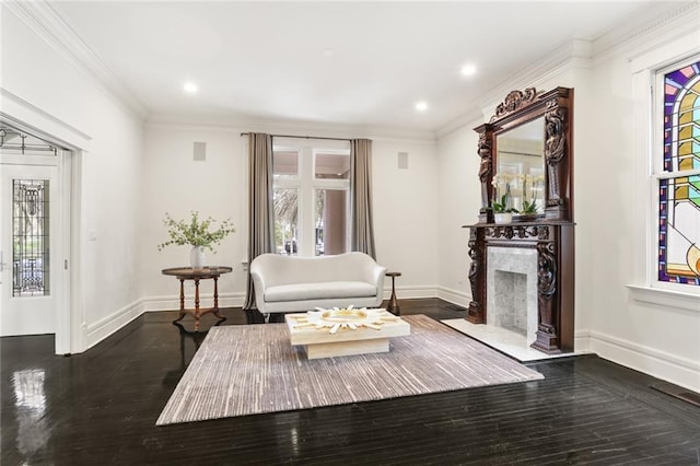 living room featuring plenty of natural light, dark wood-style floors, a fireplace, and crown molding