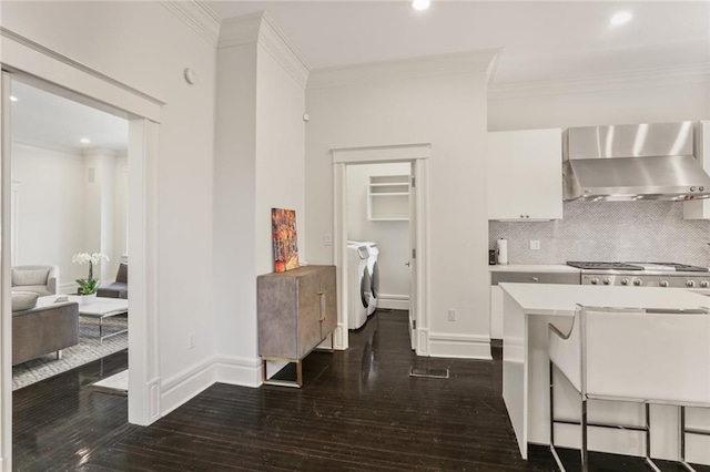 kitchen with crown molding, wall chimney exhaust hood, and separate washer and dryer