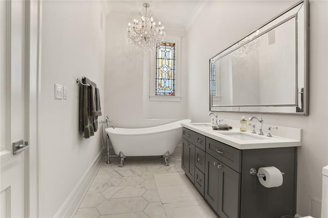 bathroom featuring a freestanding bath, double vanity, ornamental molding, a notable chandelier, and a sink