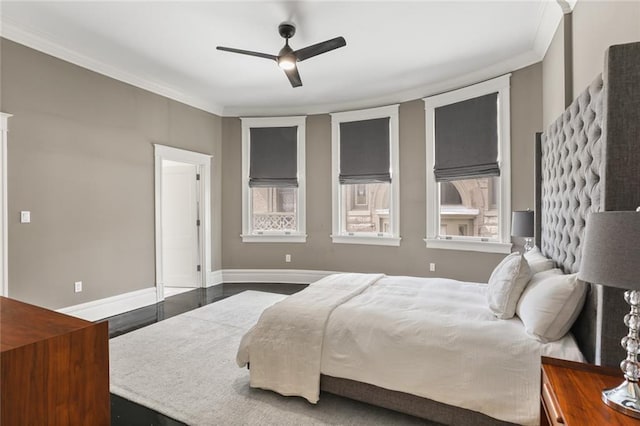 bedroom with wood finished floors, a ceiling fan, baseboards, and ornamental molding