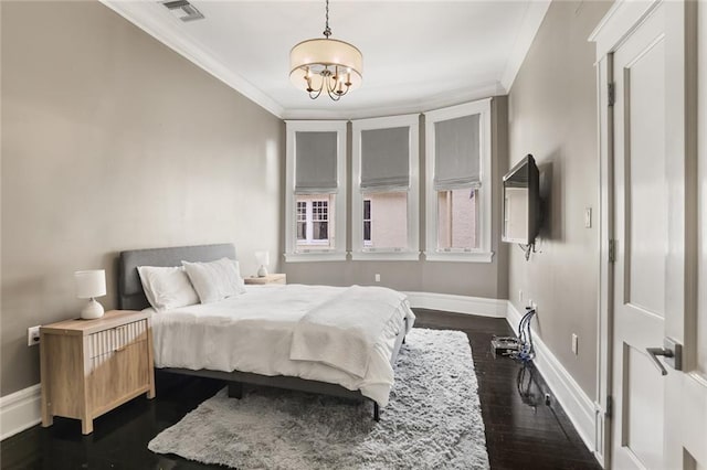 bedroom with a chandelier, dark wood finished floors, baseboards, and ornamental molding