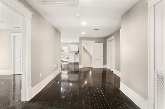 hallway featuring hardwood / wood-style floors, recessed lighting, baseboards, and visible vents