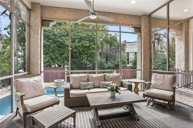 sunroom / solarium featuring a ceiling fan