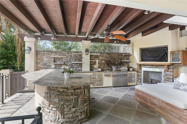 view of patio with ceiling fan, a grill, and an outdoor kitchen