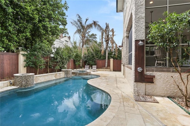 view of pool with a patio, a fenced backyard, and a pool with connected hot tub