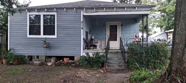 view of front of home with covered porch and a shingled roof