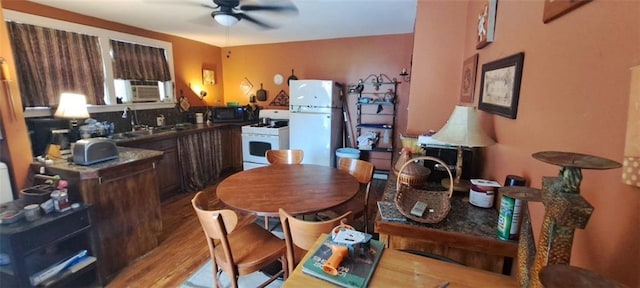 dining space with light wood finished floors, cooling unit, and ceiling fan