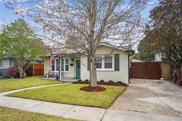 bungalow-style house with a gate, driveway, a front lawn, and fence