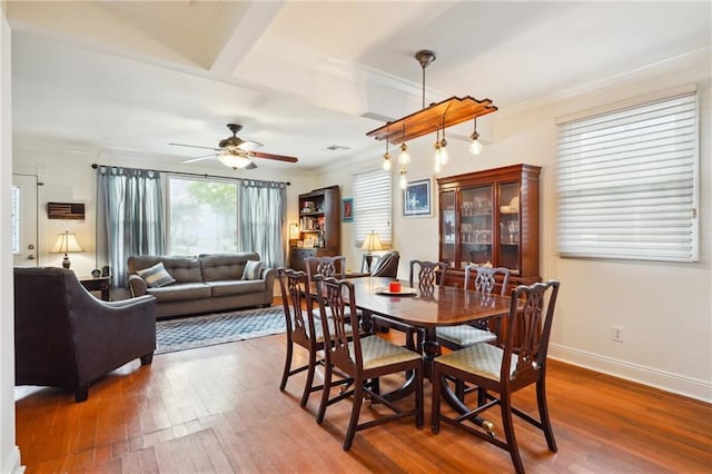 dining area featuring baseboards, ornamental molding, a ceiling fan, and hardwood / wood-style flooring