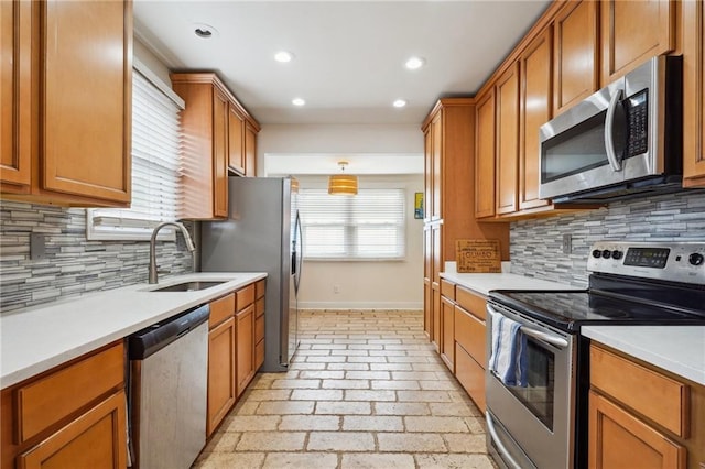 kitchen featuring a wealth of natural light, appliances with stainless steel finishes, light countertops, and a sink