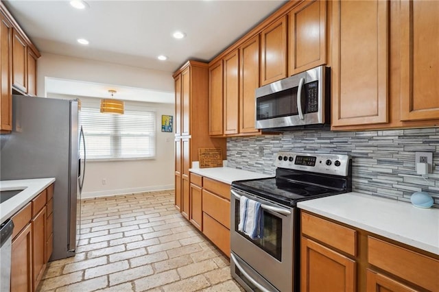 kitchen featuring decorative backsplash, light countertops, brown cabinets, and appliances with stainless steel finishes