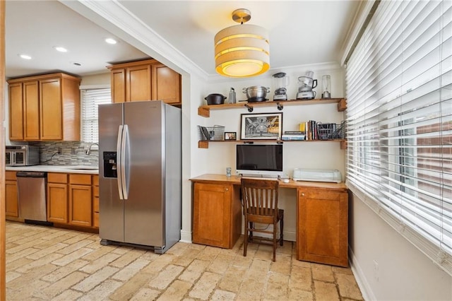 kitchen with tasteful backsplash, light countertops, brown cabinets, stainless steel appliances, and a sink