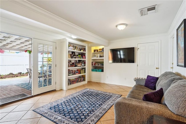 living area featuring tile patterned flooring, visible vents, built in features, and ornamental molding