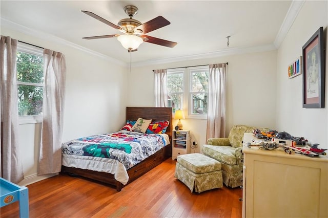 bedroom featuring crown molding, a ceiling fan, and wood finished floors