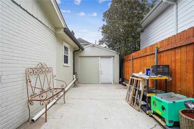 view of patio with an outbuilding, a shed, and fence