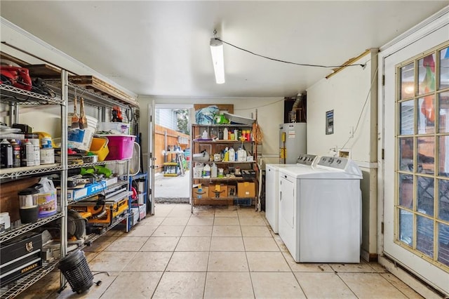 clothes washing area featuring water heater, laundry area, light tile patterned floors, and washing machine and clothes dryer