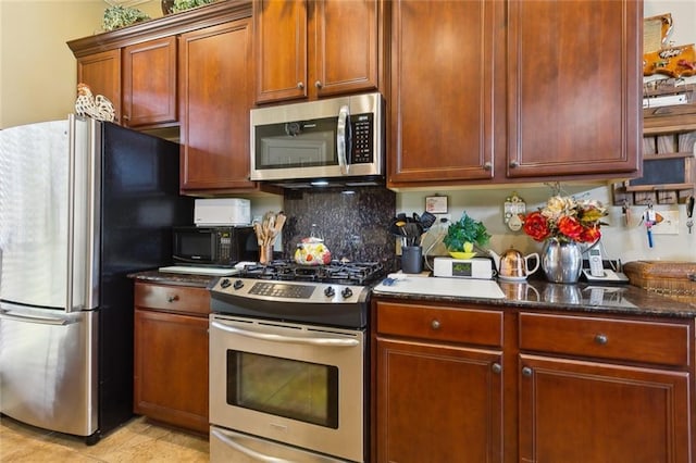 kitchen with decorative backsplash, appliances with stainless steel finishes, and dark stone counters