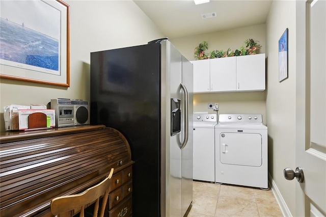 laundry area featuring baseboards, visible vents, light tile patterned flooring, cabinet space, and washer and clothes dryer