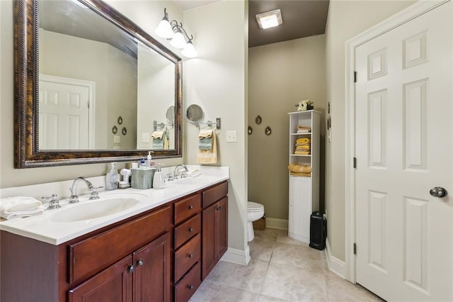 bathroom featuring tile patterned flooring, double vanity, toilet, and a sink