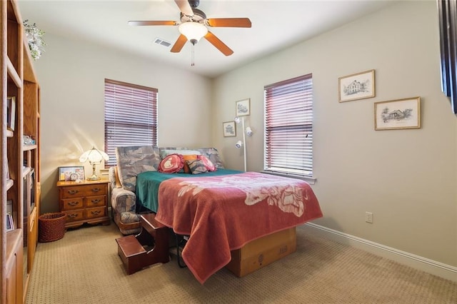 carpeted bedroom with visible vents, baseboards, and ceiling fan