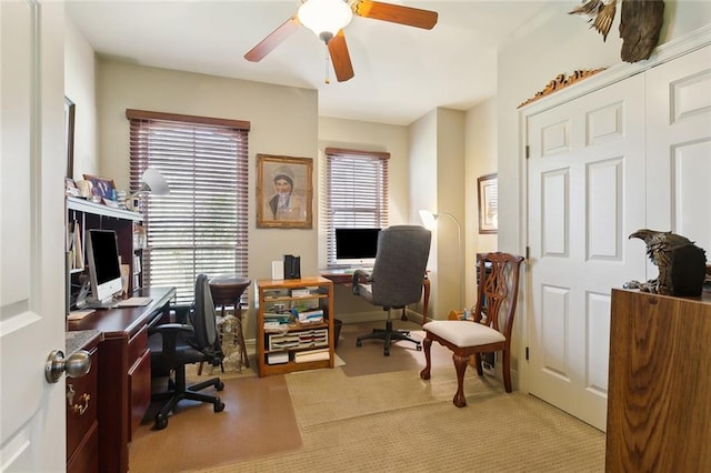 home office featuring a ceiling fan and light colored carpet