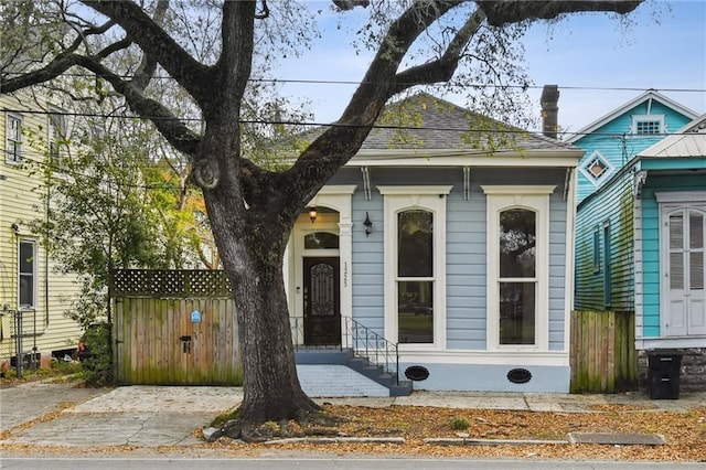 shotgun-style home featuring fence