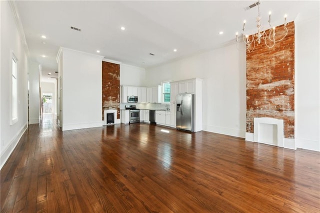 unfurnished living room with a notable chandelier, dark wood-style floors, and a large fireplace