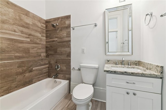 bathroom with baseboards, shower / washtub combination, toilet, wood finished floors, and vanity