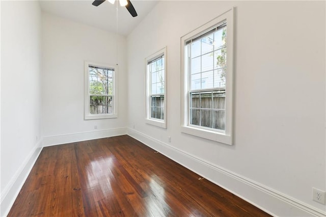 unfurnished room with baseboards, dark wood-style flooring, and ceiling fan