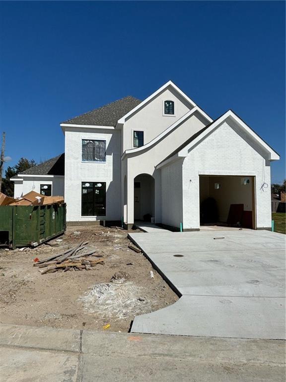 view of front facade featuring stucco siding, driveway, and a garage
