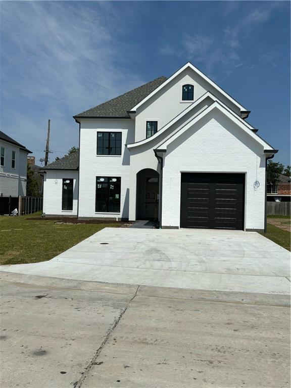 view of front of home with fence, driveway, and a front lawn