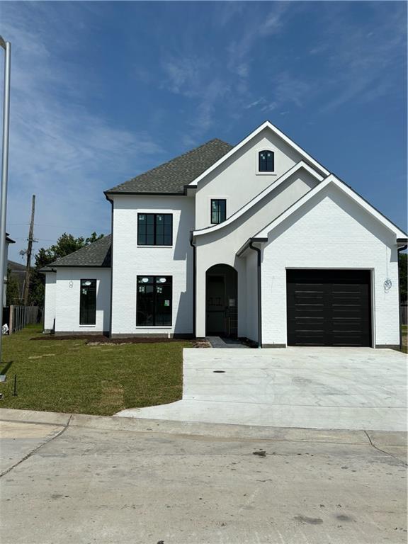 view of front of home with stucco siding, driveway, and a shingled roof