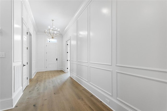11 Khan Ct, Metairie, LA 70003 - corridor featuring a decorative wall, a chandelier, and light wood-type flooring