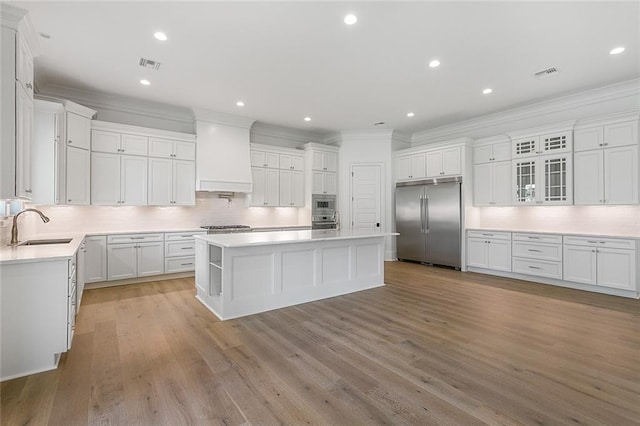 11 Khan Ct, Metairie, LA 70003 - kitchen with built in refrigerator, a sink, ornamental molding, a center island, and tasteful backsplash