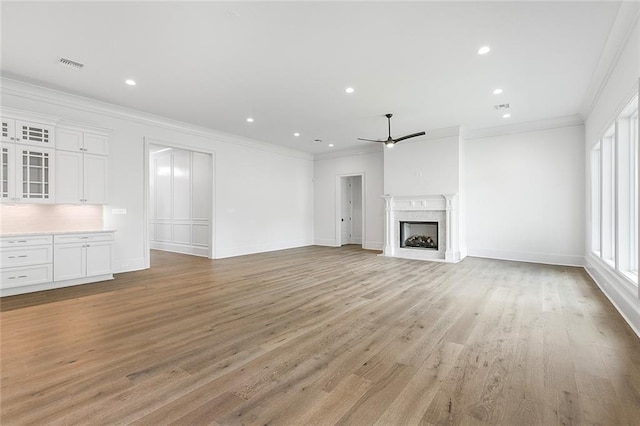 11 Khan Ct, Metairie, LA 70003 - unfurnished living room featuring ceiling fan, ornamental molding, light wood-style floors, a high end fireplace, and baseboards