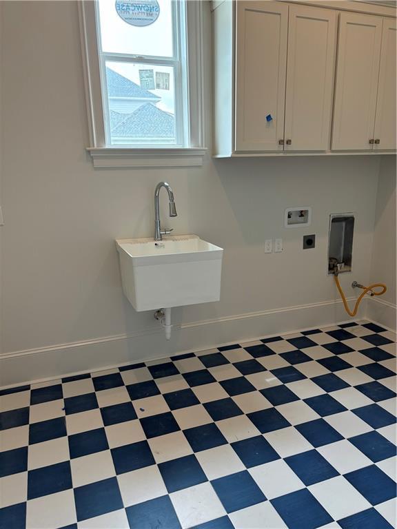 laundry area featuring electric dryer hookup, cabinet space, tile patterned floors, baseboards, and hookup for a washing machine