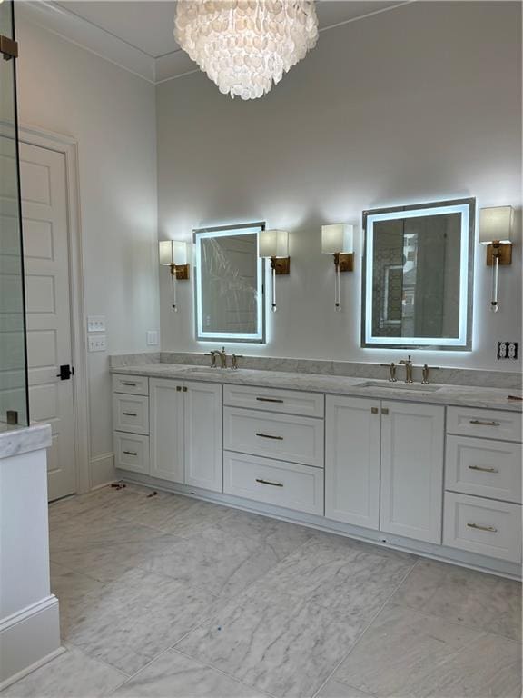 bathroom with double vanity, a sink, a notable chandelier, ornamental molding, and tiled shower
