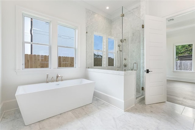 11 Khan Ct, Metairie, LA 70003 - bathroom with baseboards, a freestanding bath, a stall shower, marble look tile flooring, and recessed lighting