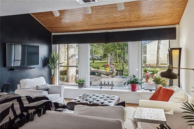 sunroom featuring wood ceiling and a healthy amount of sunlight