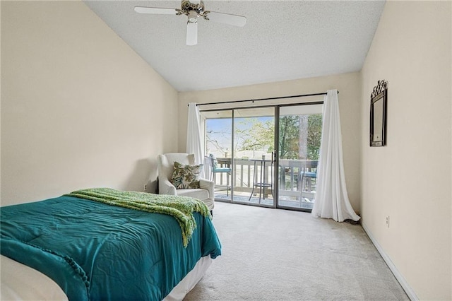 carpeted bedroom featuring a ceiling fan, baseboards, lofted ceiling, access to exterior, and a textured ceiling