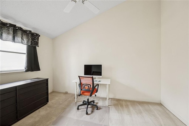 carpeted home office featuring a textured ceiling, baseboards, ceiling fan, and vaulted ceiling