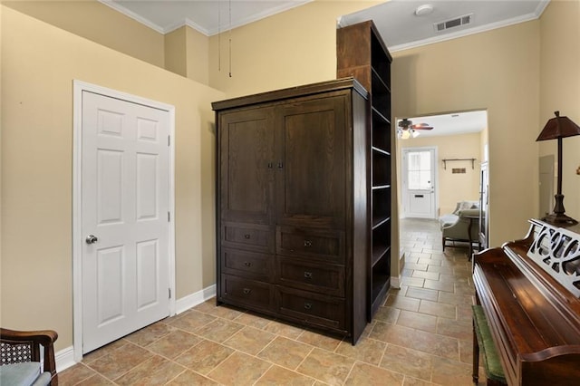 hallway with attic access, crown molding, visible vents, and baseboards