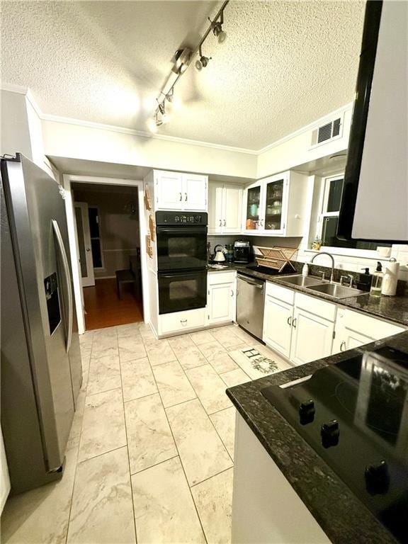 kitchen featuring visible vents, a sink, stainless steel appliances, glass insert cabinets, and white cabinetry