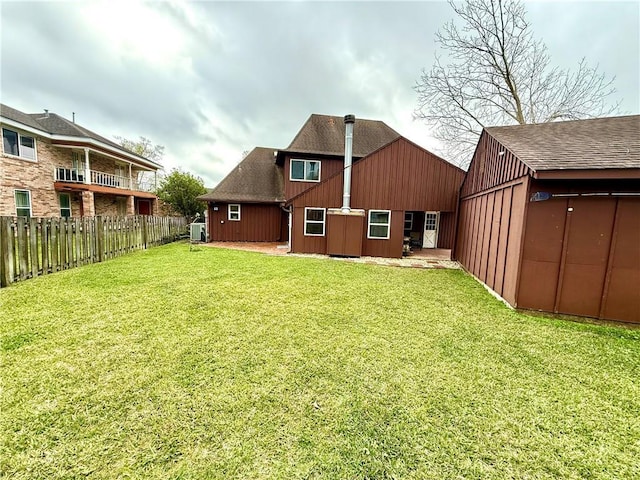 back of property featuring central AC unit, fence private yard, and a yard