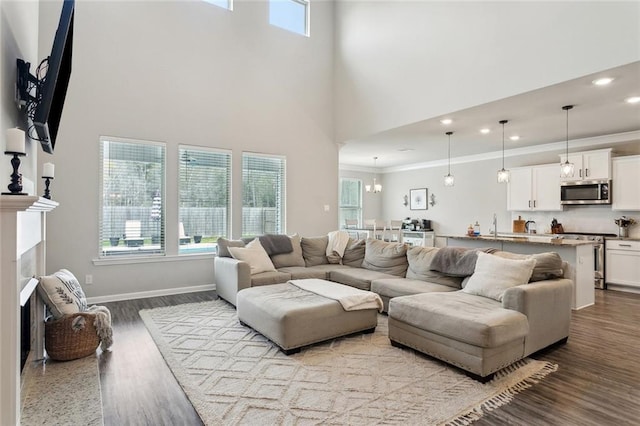living area with ornamental molding, wood finished floors, recessed lighting, a fireplace, and baseboards