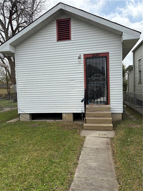 view of front of property with fence, a front yard, and entry steps